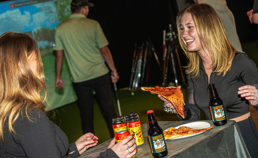 girls eating pizza, smiling and having some beers